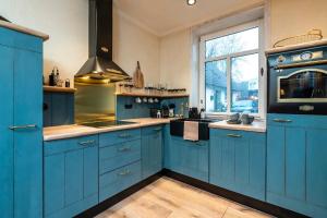 巴特塞格贝格Apartment Deluxe的蓝色的厨房,配有蓝色的橱柜和窗户