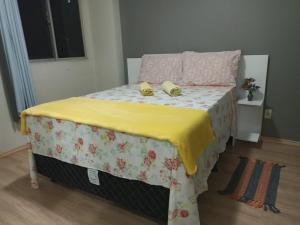 马塞约Braga Apartamento Temporada Maceió的床上有两张黄色拖鞋
