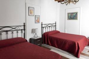 ArmarizA Pousa Pensión rural (Camino de Santiago Sanabrés)的一间卧室配有两张带红色床单和灯的床