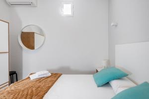 马德里Minty Stay - Hortaleza Studio的白色卧室配有床和镜子