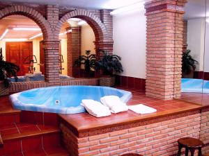兰哈龙Hotel el Sol的大型浴室设有大型浴缸和两个拱门
