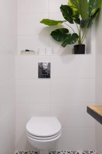 耶路撒冷Aju Ben Yehuda 23的白色的浴室设有卫生间和植物