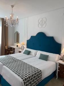塞维利亚塞维利亚德比酒店的一间卧室配有一张大床和蓝色床头板