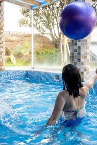 Yanque特拉迪逊科尔卡酒店的身穿大紫球的游泳池中的女人