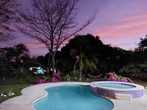 Las UvasBEAUTIFUL HOUSE IN LAS UVAS SAN CARLOS, PANAMA WITH FRUIT TREES -SWIMMING POOL的一座游泳池,位于一个享有日落美景的庭院内