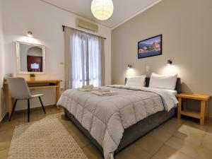 爱琴娜岛埃伊纳岛酒店的一间卧室配有一张大床、一张桌子和一把椅子