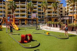 卡波圣卢卡斯卡萨朵拉达洛斯卡沃斯度假Spa酒店的两个孩子在度假村的游乐场玩耍