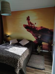 蒙泰夫兰Lodge Du Petit Lion proche DISNEYLAND PARIS的一间卧室,配有一张床铺,悬崖上有一只猴子