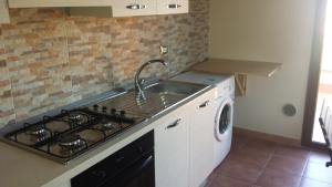 巴列塔Barletta Con Vista的厨房配有水槽、炉灶和洗衣机。
