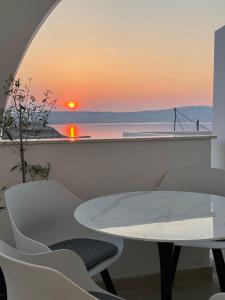 西尼卡Apartment Vila **的桌椅,背面是日落