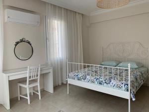 费特希耶Kaya Suite的一间卧室配有一张床、一张书桌和一面镜子