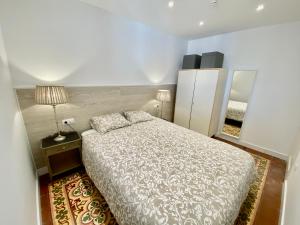 科尔内拉德罗布雷加特Suite Apartment Anselm Barcelona的一间卧室配有一张床、一盏灯和一面镜子
