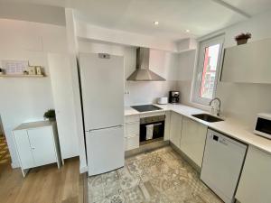 科尔内拉德罗布雷加特Suite Apartment Anselm Barcelona的白色的厨房配有冰箱和水槽