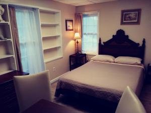 盖茨堡Sleepy Hollow Manor的卧室配有一张床和一张桌子及椅子