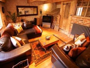 克罗姆福德The Malthouse的客厅配有真皮沙发和桌子