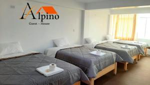 瓦拉斯Alpino Guest House的酒店客房设有三张床,墙上有标志