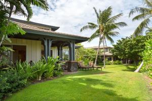 瓦克拉Mauna Lani 2002的一座房子,拥有绿草和棕榈树的庭院