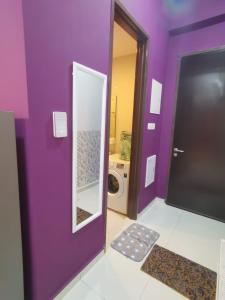 新山COUNTRY GARDEN@J Agape Homestay ~ STUDIO COMFORT的紫色浴室设有洗衣机和镜子