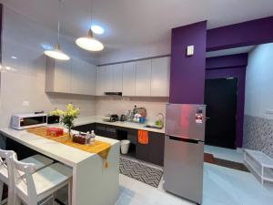 新山COUNTRY GARDEN@J Agape Homestay ~ STUDIO COMFORT的厨房配有紫色和白色的橱柜和冰箱。