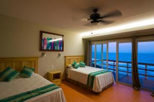 埃尔库科阿尔瓦多洛斯曼戈斯酒店的一间带两张床的卧室,享有海景