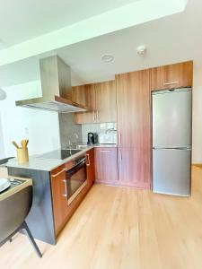 贝纳斯克Apartamento Valle de Alba的厨房配有木制橱柜和不锈钢冰箱。