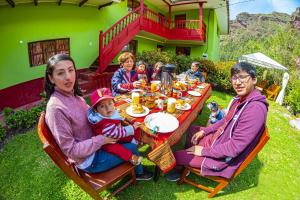 乌鲁班巴Happy Land Valle Sagrado的坐在院子里桌子上的一群人