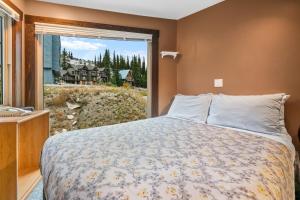 大白山Cozy Corner - Whitefoot Lodge 126的一间卧室设有一张床和一个大窗户