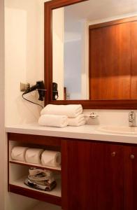 圣地亚哥公园广场公寓酒店的浴室配有盥洗盆、镜子和毛巾