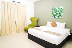 珍南海滩SANDY GARDEN RESORT LANGKAWI的一间卧室配有一张床和一把绿色椅子