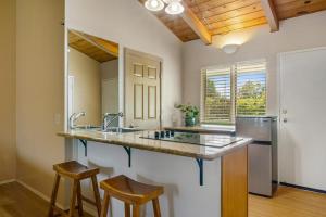 怀梅阿Castle Waimea Country Lodge的厨房配有水槽和2个吧台凳