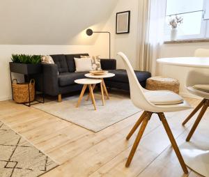 鲁斯特Mirielle Apartments的客厅配有沙发和桌椅