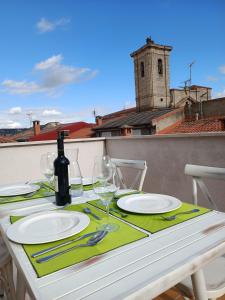 Pesquera de DueroHotel Rural Envero的阳台上的桌子上摆放着盘子和酒杯