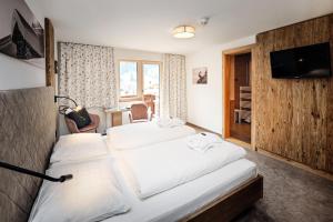 圣加伦基希Hotel Alpenfeuer Montafon的酒店客房设有两张床和电视。