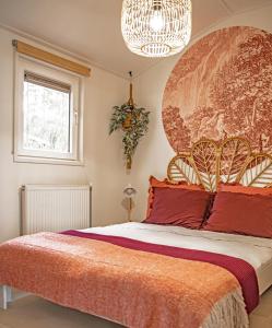 伊皮StayatSas Tiny House Sam in de bossen op de Veluwe!的一间卧室配有一张带红色枕头的大床
