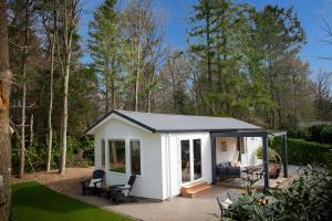 伊皮StayatSas Tiny House Sam in de bossen op de Veluwe!的庭院中带庭院的白色小棚子