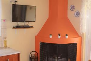 卡拉米锡Alexandra's Apartment的客厅设有壁炉,上面配有电视