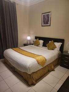 艾卜哈Safwt Aldyar Furnished Units的一间卧室配有一张大床,提供黄色毯子和枕头
