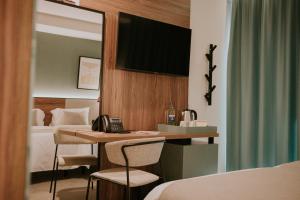 大加那利岛拉斯帕尔马斯Hotel Catalina Plaza Sostenible的酒店客房配有带电话和床的书桌
