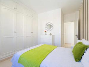 阿雷西费Mahostly Apartamento Comillas SC的一间白色卧室,床上铺有绿毯