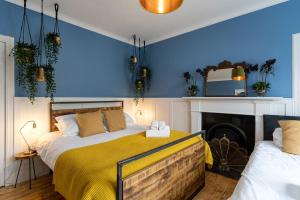 金尤西50TheHighstreet by The House of Danu的一间卧室设有蓝色的墙壁、一张床和一个壁炉