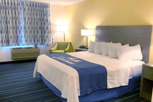 欣克利欣克利戴斯酒店的酒店客房带一张大床和一把椅子