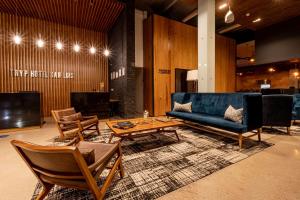 圣路易斯波托西TRYP by Wyndham San Luis Potosi Hotel & Suites的客厅配有沙发、椅子和桌子