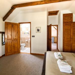 朗塞斯顿Ta Mill Cottages & Lodges - Hayloft Cottage的一间卧室配有一张床,浴室设有卫生间