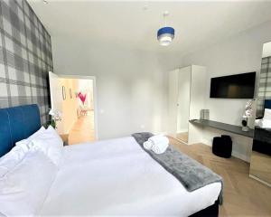 爱丁堡Luxury Reno'd 1 Bed Nr Bruntsfield & The Meadows的卧室配有一张白色大床和电视。