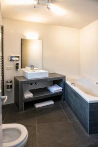 阿珀尔多伦帕里斯咖啡酒店的一间带水槽、浴缸和卫生间的浴室