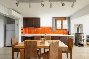 梅塔诺佛希斯#FLH - Vitamin Sea Beachfront Villa, Sithonia的厨房配有木桌和一些椅子