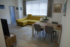 班斯卡 - 什佳夫尼察Apartmány Kammergraf的客厅配有黄色的沙发和桌子