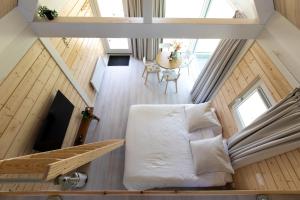 多克姆Tiny house - optioneel met hottub的阁楼卧室配有1张床和1张桌子