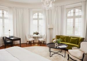 斯德哥尔摩斯德哥尔摩外交官酒店的客厅配有绿色沙发和桌子