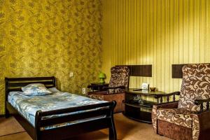 扎波罗热SEM宾馆的一间卧室配有一张床、两把椅子和一张桌子